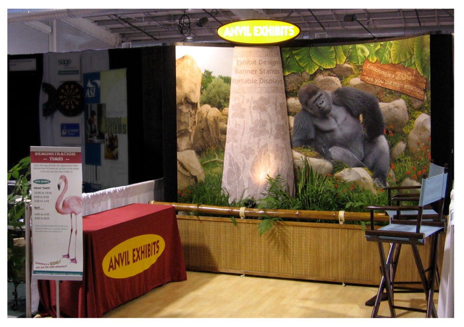 This is a custom trade show seminar booth display with a backwall, table throw, poster and folding chair.